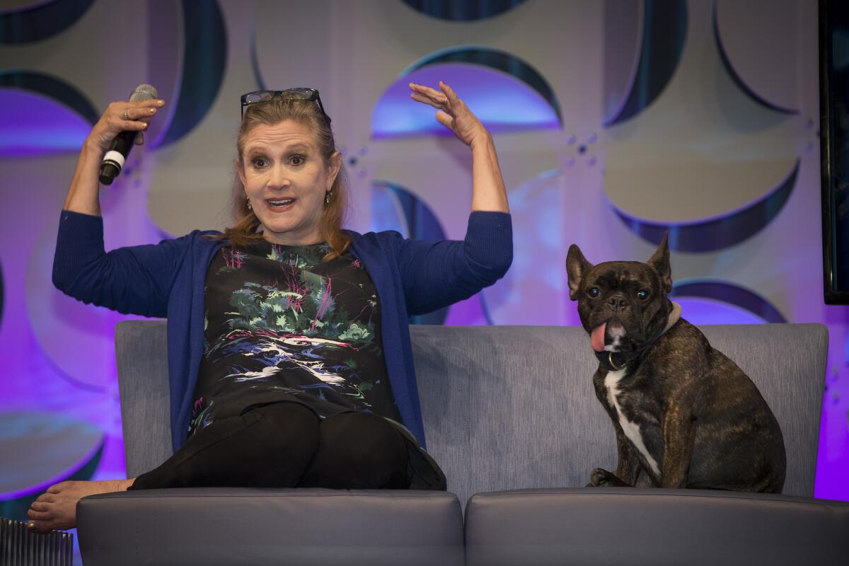 "Star Wars" actress Carrie Fisher, joined by her dog Gary, talks onstage during her presentation at Star Wars Celebration on April 17 at the Anaheim Convention Center.