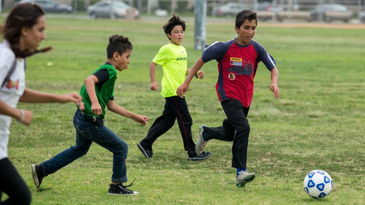 Mohammad Zahid, right, takes the ball upfield during a game Aug. 23 at World Cup Soccer Summer Camp in Westminster.