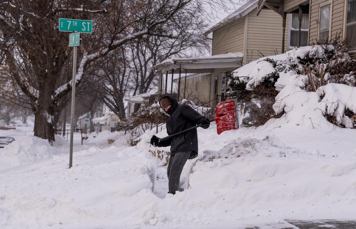 With barely his face showing in the -10 degree temperature, a youngster shovels a path to his house.