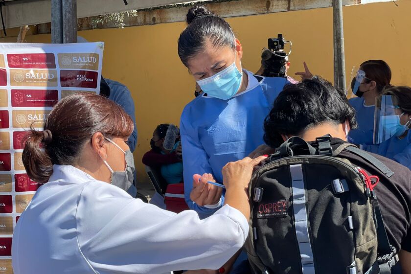 Una enfermera aplica la vacuna contra COVID=19 en el campamento de migrantes en El Chaparral en Tijuana, Baja California.