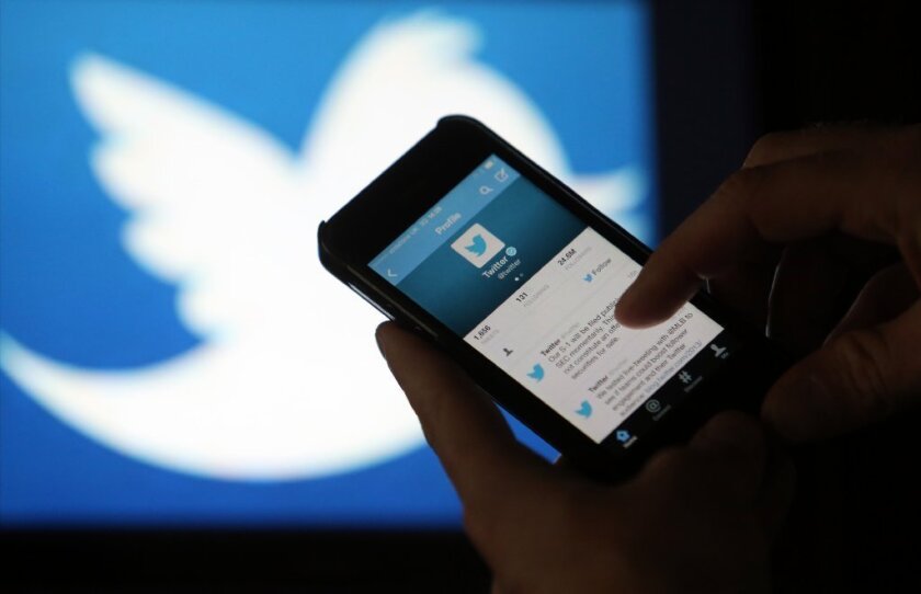 Un usuario se desplaza por un feed de Twitter en la pantalla de un iPhone.