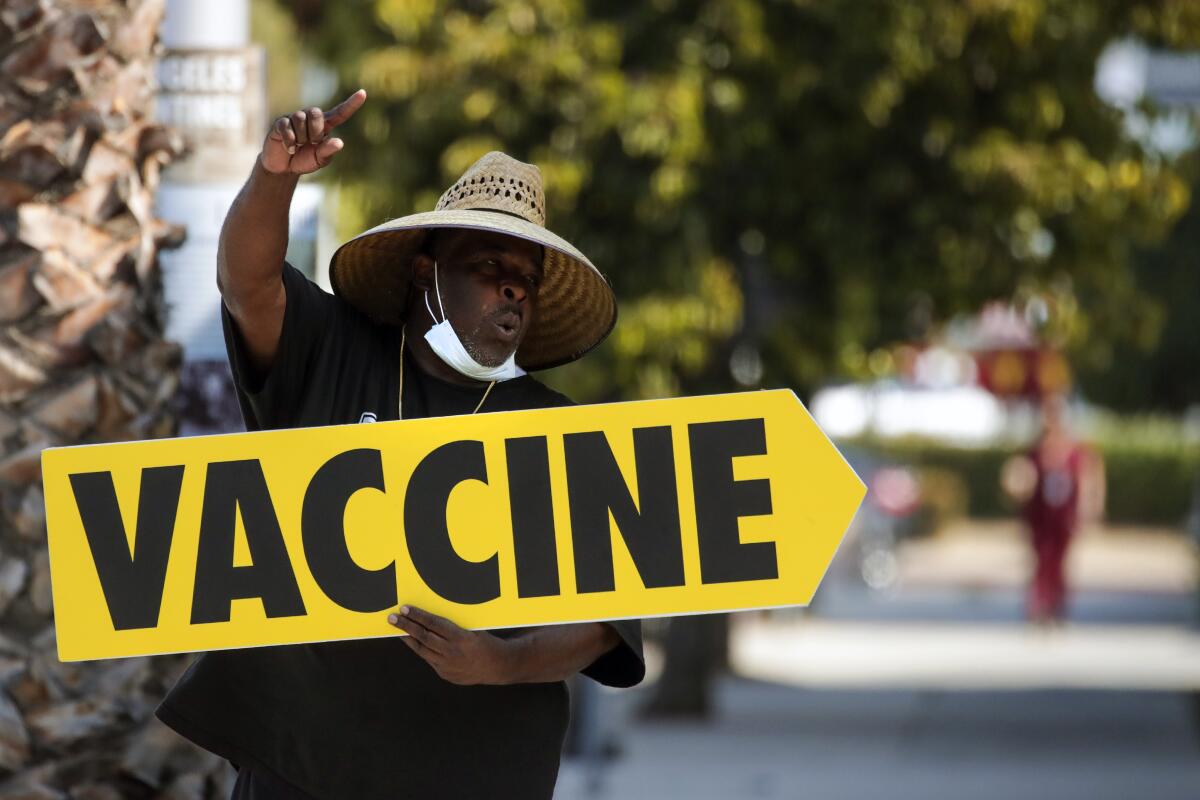 Willie Golden directs people toward a mobile COVID-19 vaccine clinic in Los Angeles on July 16. 