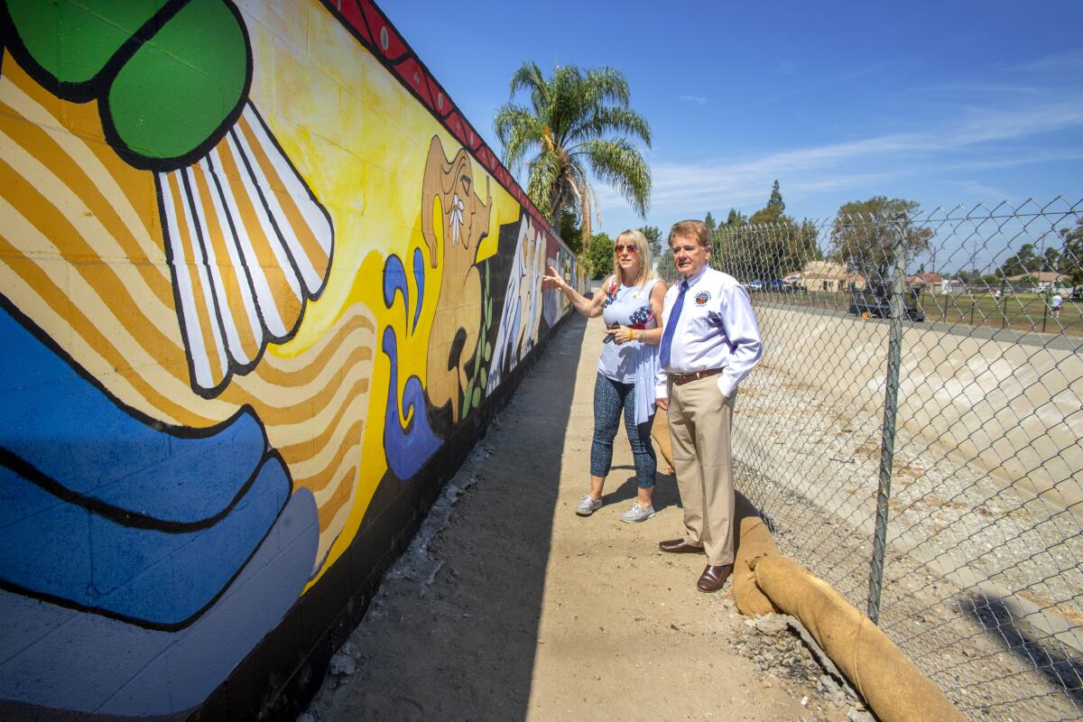 Placentia Mayor Rhonda Shader and county Supervisor Doug Chaffee check out the restored Atwood mural during the celebration event.