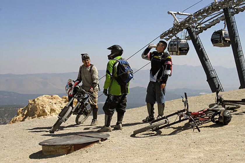 Gustav Betanvourth, left, and friends take a break before heading down a bike trail at Mammoth Mountain.