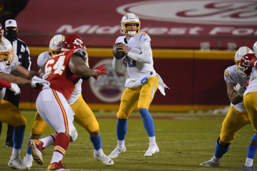 Los Angeles Chargers quarterback Justin Herbert, center, throws a pass during the second half of an NFL football game against the Kansas City Chiefs, Sunday, Jan. 3, 2021, in Kansas City. (AP Photo/Jeff Roberson)
