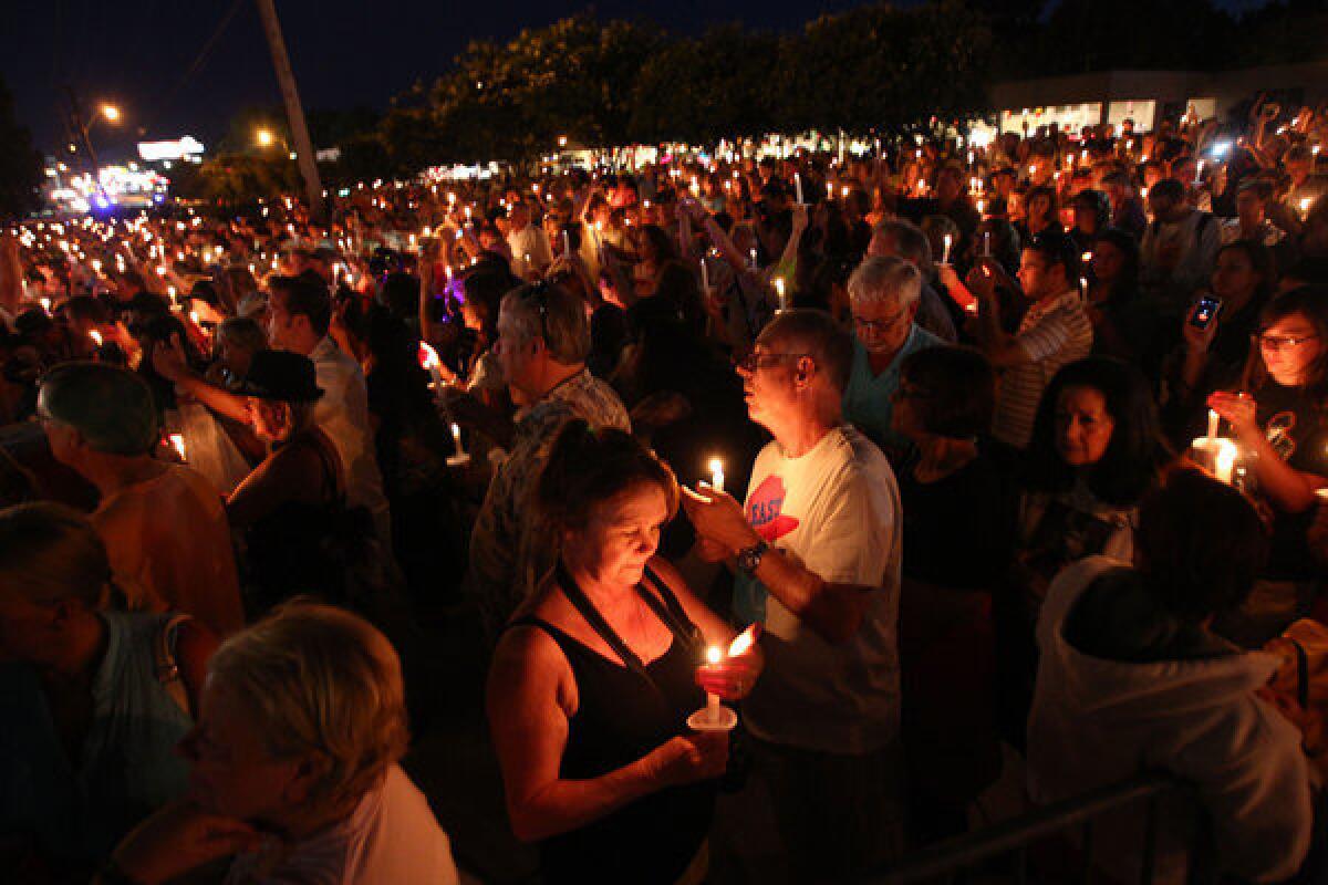 Fans of the late Elvis Presley gather at Graceland, the performer's home, for a candlelight vigil on Aug. 15, 2013, in Memphis, Tenn.