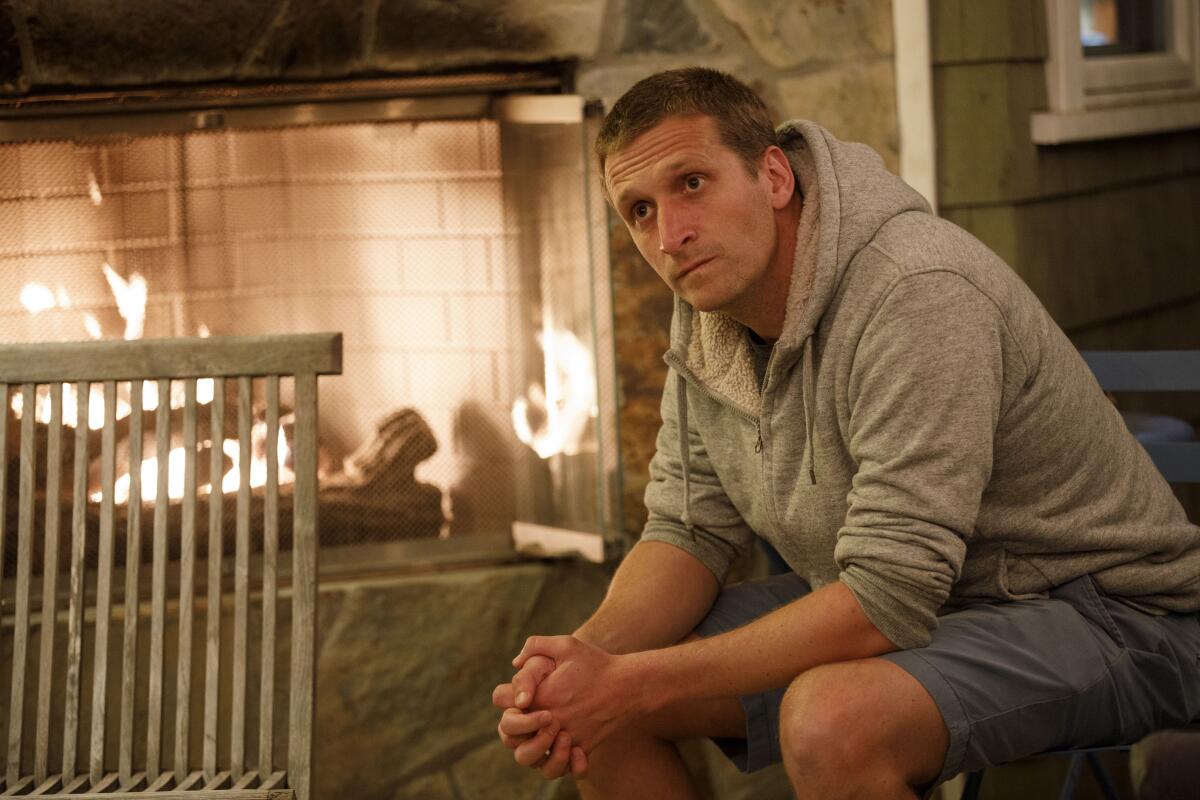 Andrew Herzik by the fireplace in his backyard.