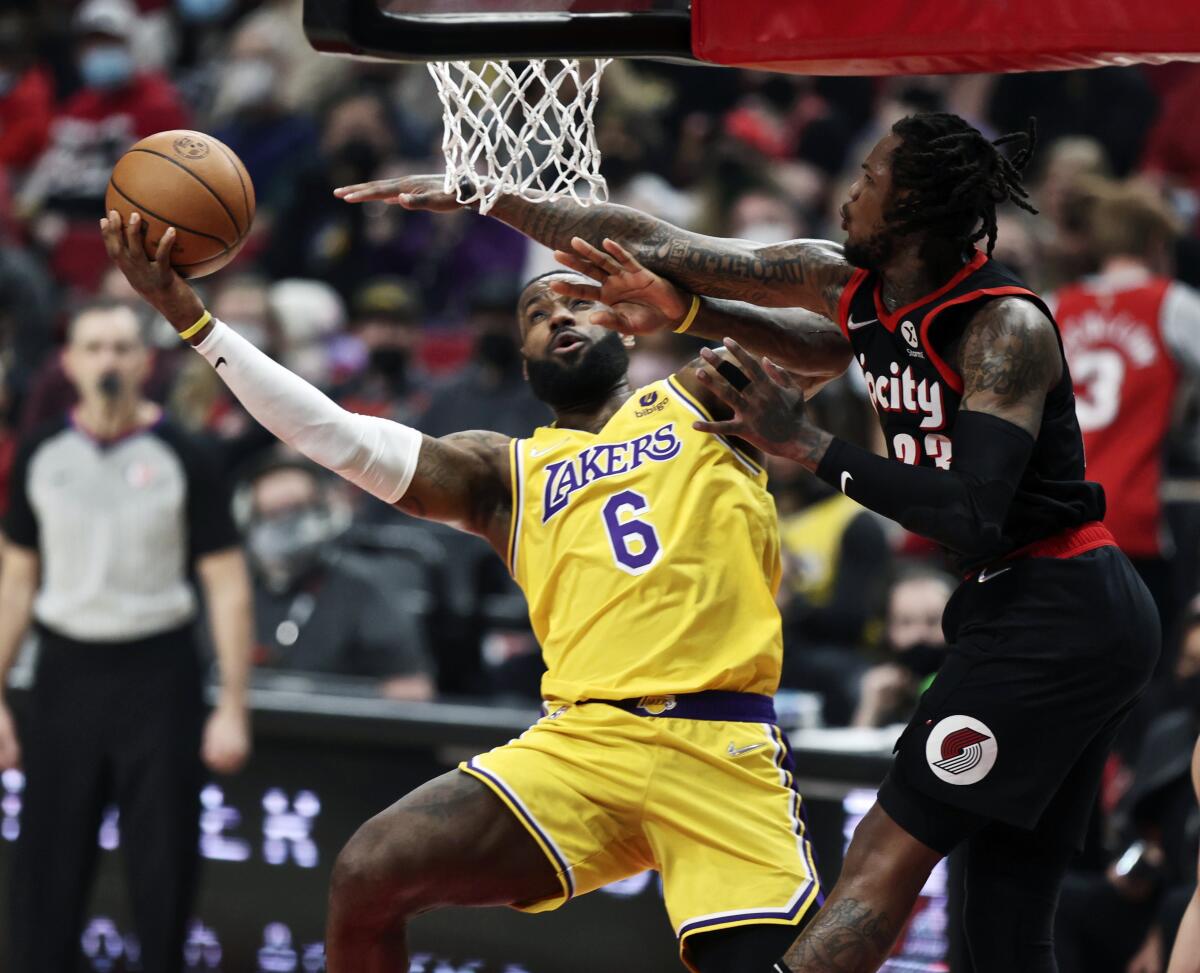 Lakers forward LeBron James shoots as Portland Trail Blazers guard Ben McLemore defends.