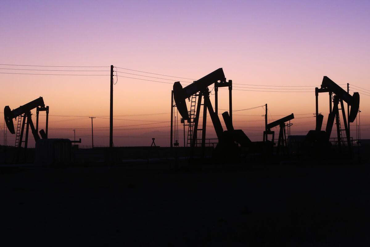Oil pumpjacks silhouetted against twilight