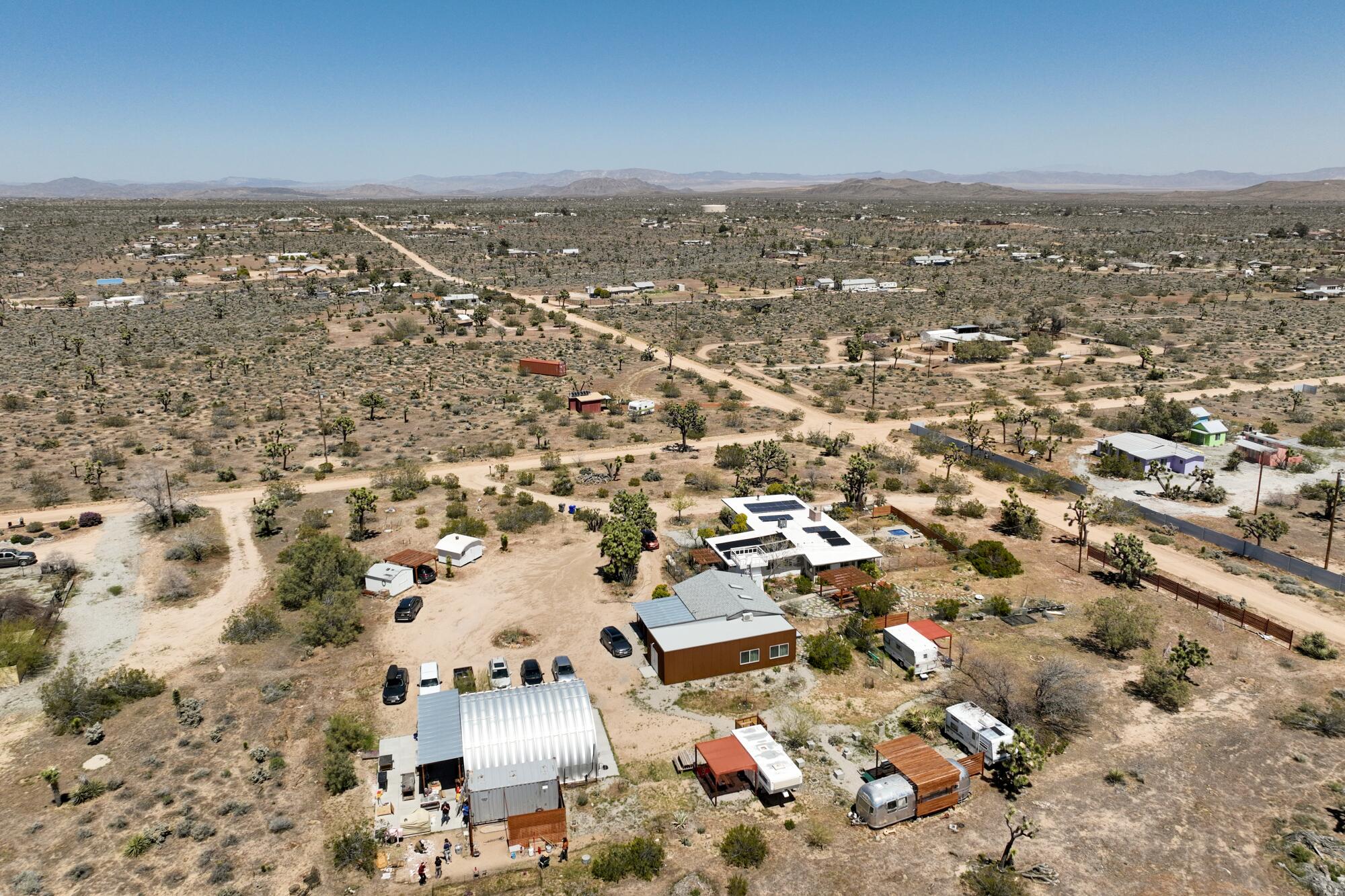 The buildings sprawl across a desert property dotted with bushes and trees.