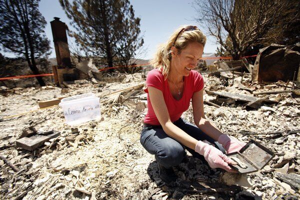 Holly Solberg looks through the debris of her mother's Lake Hughes home on Newview Road that was destroyed by the Powerhouse fire. Holly and her five siblings were raised in the house that her parents, Dorothy and Howard Solberg, moved into 44 years ago.