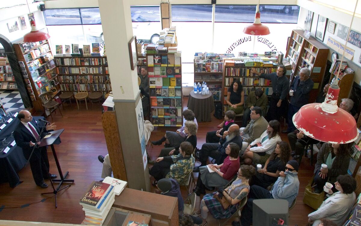 Harold Augenbraum, left, executive director of the National Book Foundation, announces the National Book Award finalists at San Francisco's City Lights Bookstore in 2006.