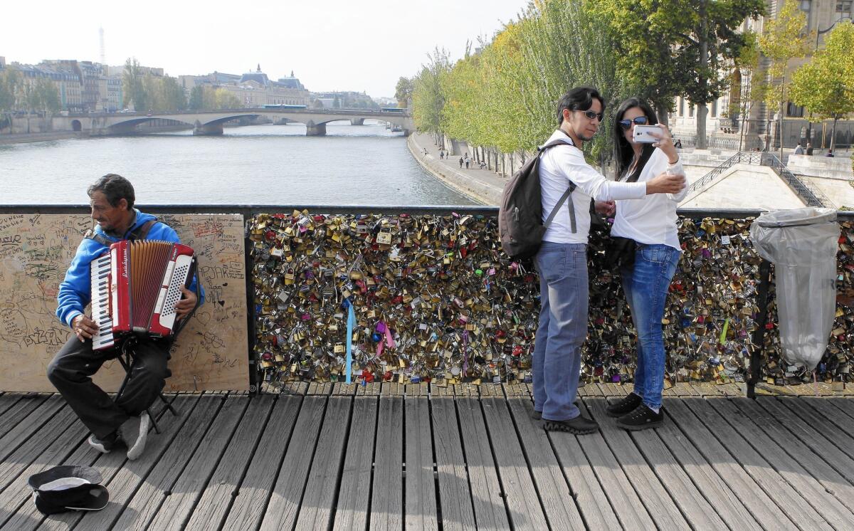 The Pont Des Arts in Paris is being covered with padlocks attached by tourists. Several railings have collapsed under the weight and sections have been boarded up for safety and to block more “love locks.”