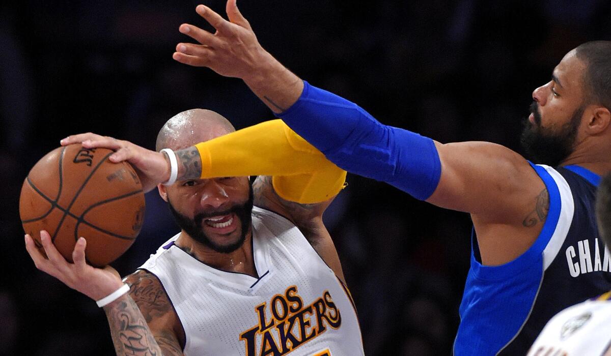 Lakers forward Carlos Boozer looks to pass while under pressure from Mavericks center Tyson Chandler in the first half Sunday.