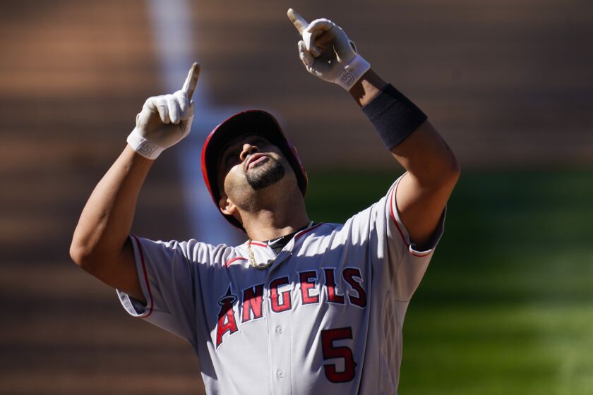 Los Angeles Angels' Albert Pujols gestures as he crosses home plate after hitting a two-run home run.