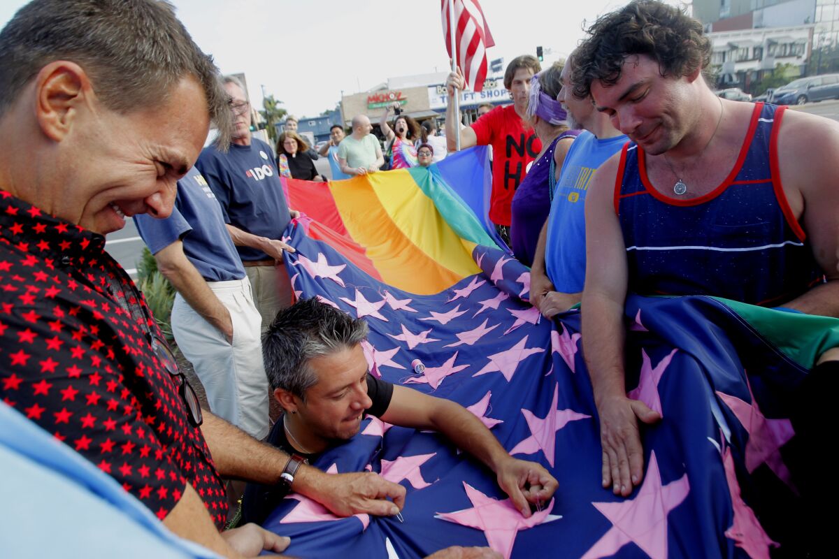 The final stars are sewn on the Pride constellation flag before being raised.