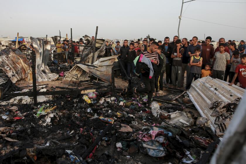 FILE - Palestinians look at the destruction after an Israeli strike where displaced people were staying in Rafah, Gaza Strip, Monday, May 27, 2024. Throughout its grinding seven-month war against Hamas, Israel has pledged to investigate a series of deadly events in which its military forces are suspected of wrongdoing. The commitment comes in the face of mounting claims — from human rights groups and the International Criminal Court's chief prosecutor — that the country's leaders are committing war crimes in Hamas-ruled Gaza. (AP Photo/Jehad Alshrafi, File)