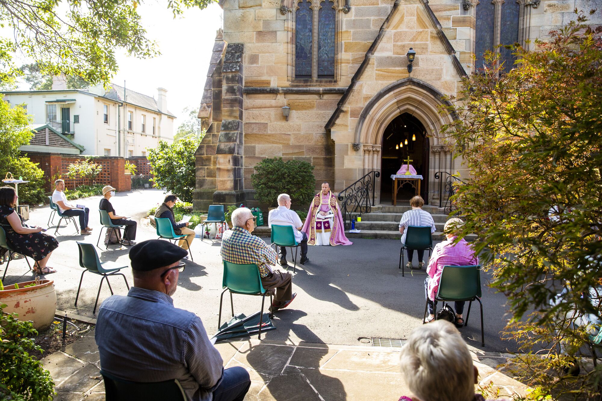 AUSTRALIA: Father James Collins holds a service in the yard of St. Paul's Anglican Church in Burwood with seating observant of social distancing in Sydney, Australia. Churches across Sydney have opted to suspend services or hold them outdoors in response to the pandemic.