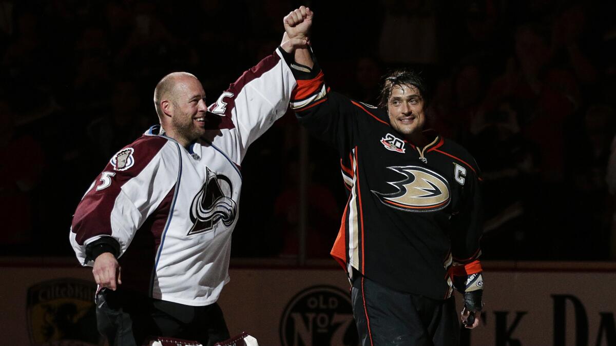 Colorado Avalanche goalie Jean-Sebastien Giguere, left, and Ducks forward Teemu Selanne acknowledge the cheers of the crowd after the final regular-season contest of their careers in Denver on April 13, 2014.