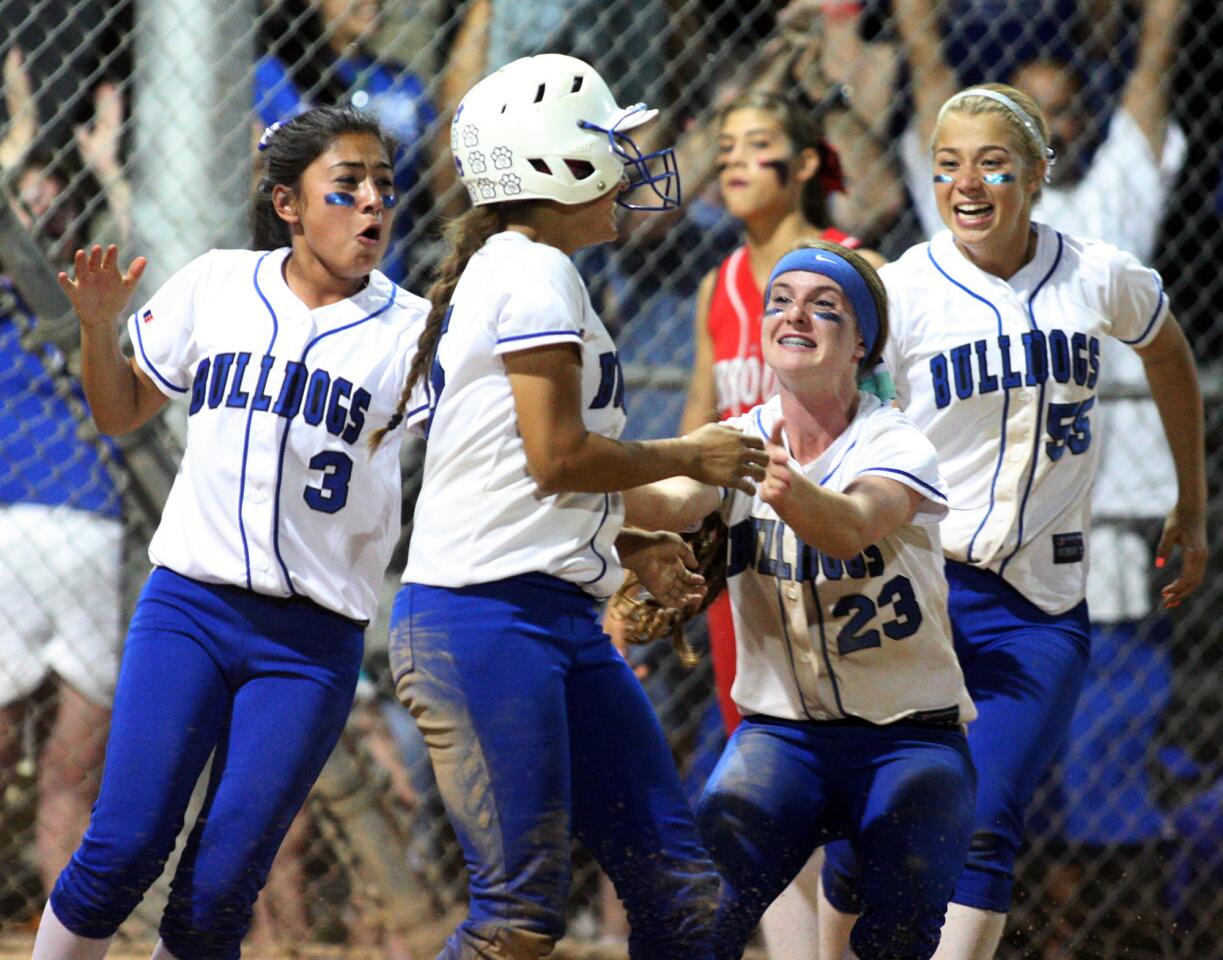 Burbank's Priscilla Romero, Cailey Stevenson, and Cailey Stevenson run to celebrate the winning run scored by teammate Bridgette Pisa in the 9th inning of a rival cross-town Pacific League softball game against Burroughs on Wednesday, May 14, 2014.