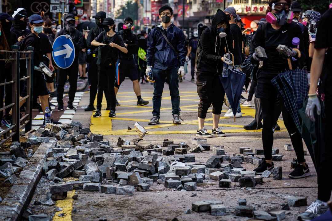Protesters pull out bricks from the sidewalk to use as road blocks and for throwing, near the Jordan district of Hong Kong.