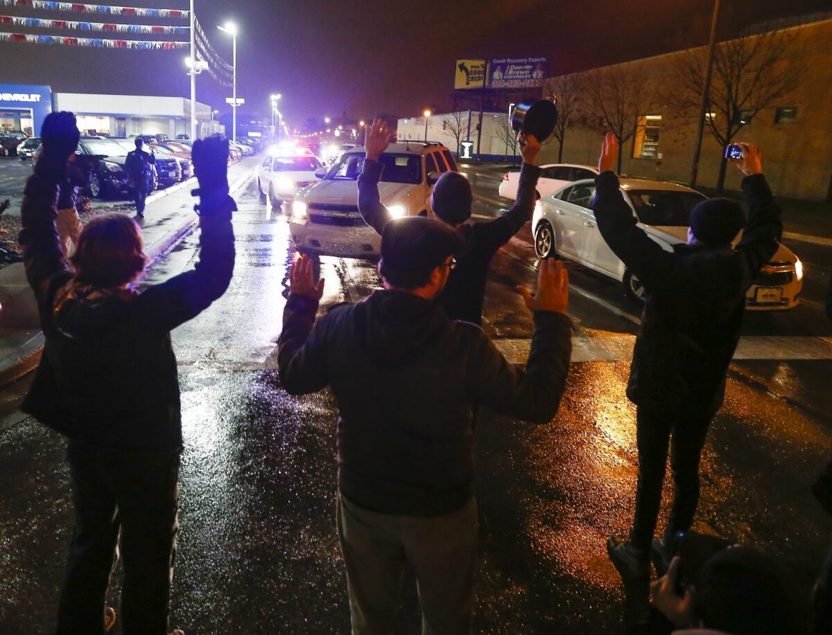 Protesters march shouting slogans, carrying signs and blocking intersections on Sunday in St. Louis.