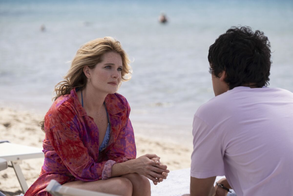 A woman and a man are having a serious conversation on the beach.