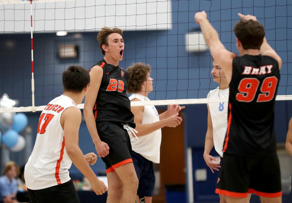 Huntington Beach's Jake Upham (20) reacts to a kill during a Surf League boys' volleyball match against Corona del Mar.