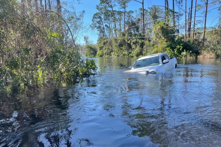 Un auto sumergido en una inundación, el viernes 30 de septiembre de 2022, en North Port, Florida. (AP Foto/Adriana Gomez Licon)