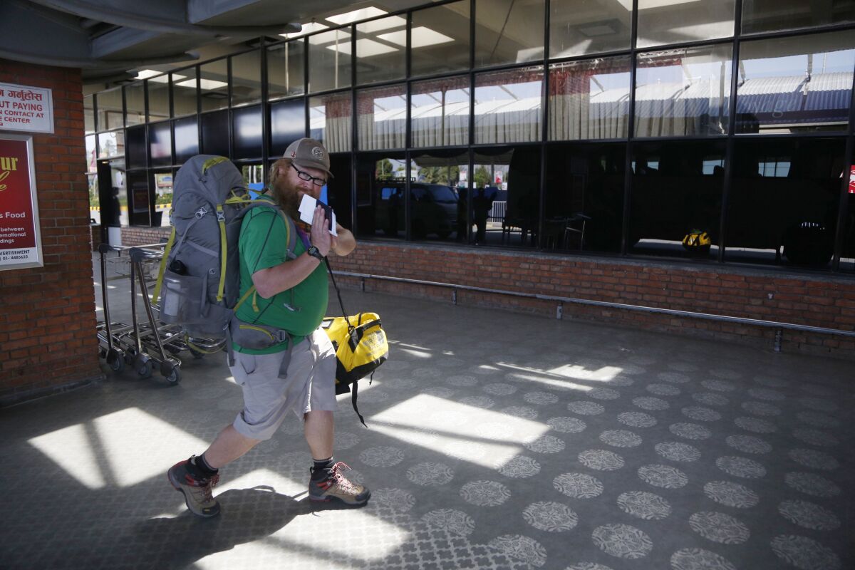 An American citizen arrives at an airport Kathmandu, Nepal, on Tuesday for a U.S.-bound flight.