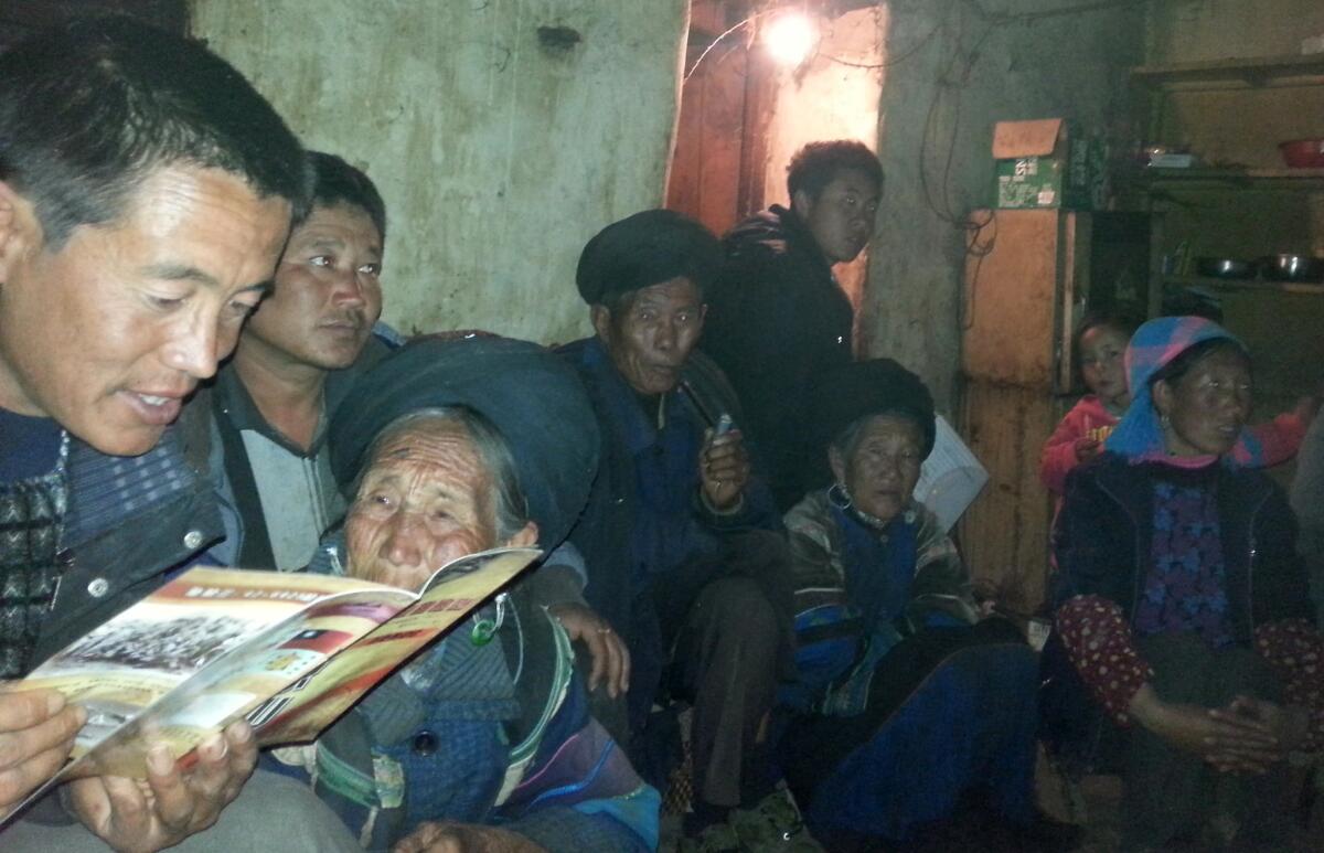 Bai Qugang and his mother, Jiaba Yiniu, look over a pamphlet about crashed flyers in the 1940s.