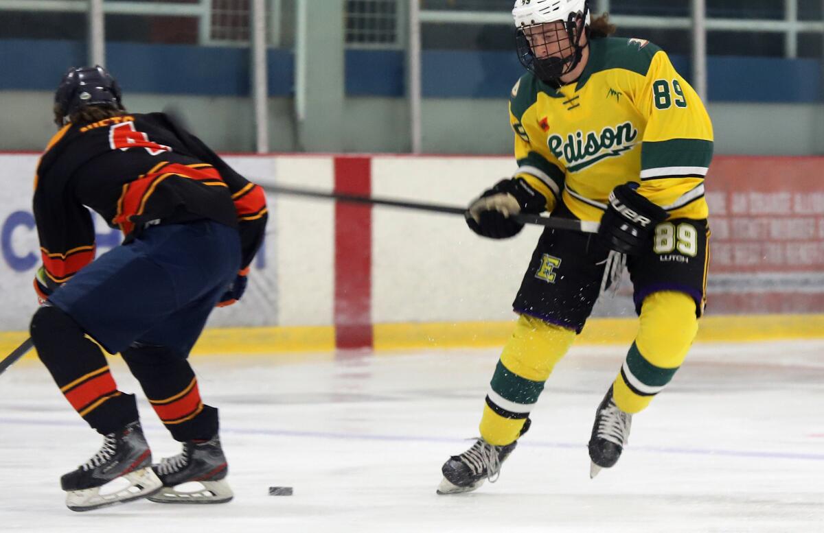Beach Cities' Conner Nieto (4) and Edison's William Lloyd II (89) battle for the puck during a game at Lakewood Ice.
