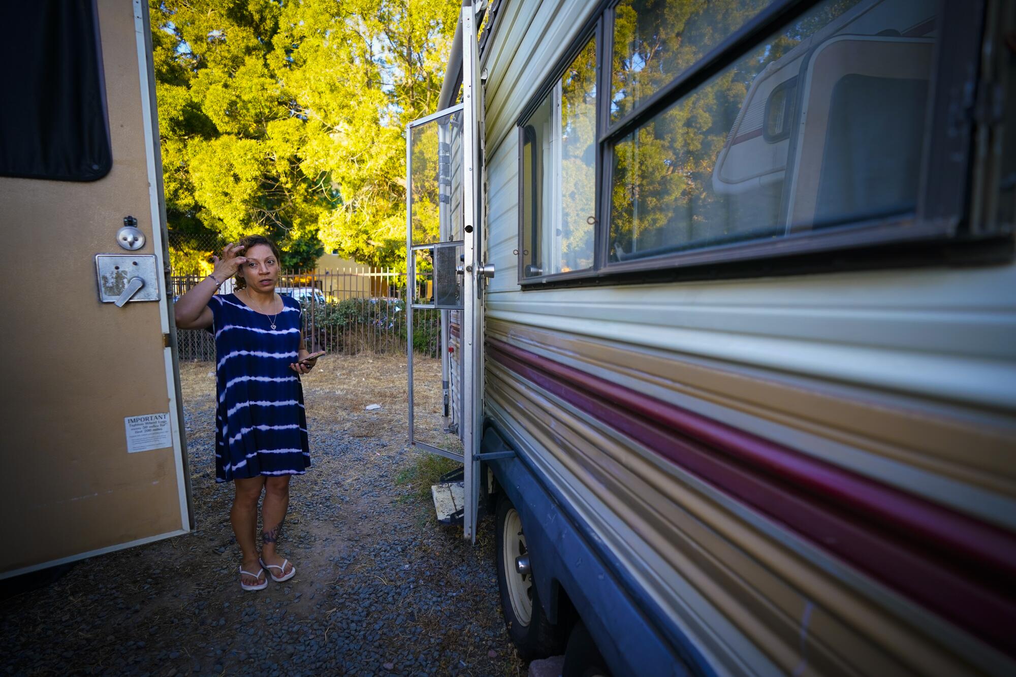 A woman stands outside an RV trailer