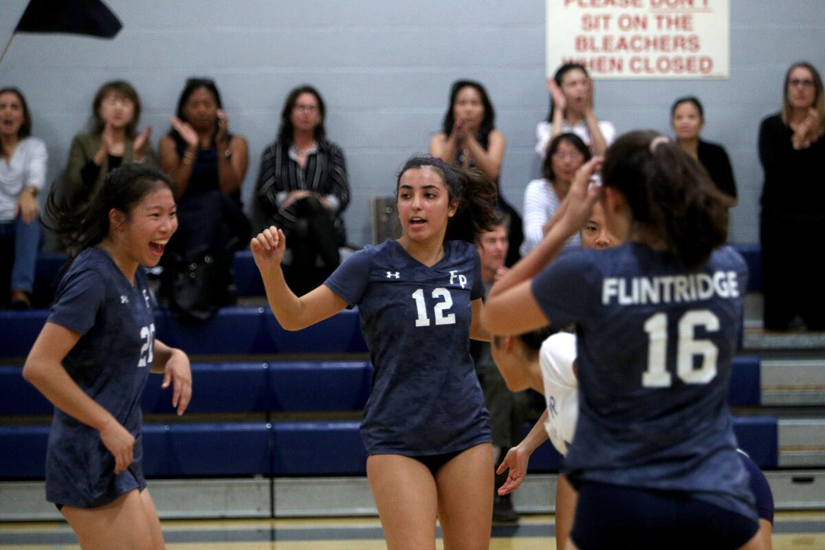 Flintridge Prep girls' volleyball players #12 Ani Bernardi, center, and others celebrate a point in game vs. Chadwick, at home in La Canada Flintridge on Tuesday, Oct. 1, 2019.