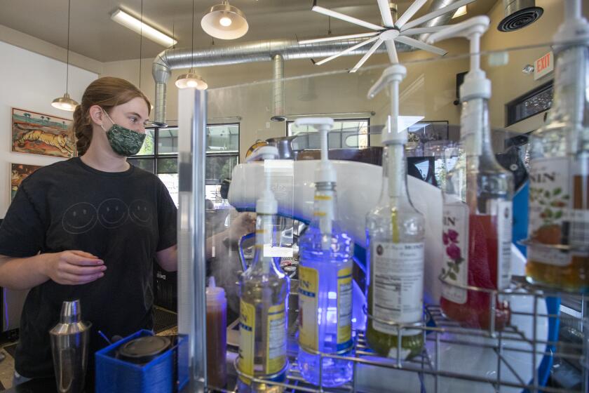 SOUTH PASADENA, CA - JULY 18: Barista Ava Dorny, 15, is wearing a face mask as she works at Charlie's Coffee House during the coronavirus pandemic on Sunday, July 18, 2021 in South Pasadena, CA. Once again the Los Angeles County on Sunday began requiring people to wear masks in indoor public places, opening a new battle line as the coronavirus is rising significantly among unvaccinated people. L.A. County is by far the biggest jurisdiction in the nation to require masks again. But with coronavirus cases rising across the nation largely because of the highly infectious Delta variant, officials elsewhere will be watching to see if the effort works. (Francine Orr / Los Angeles Times)