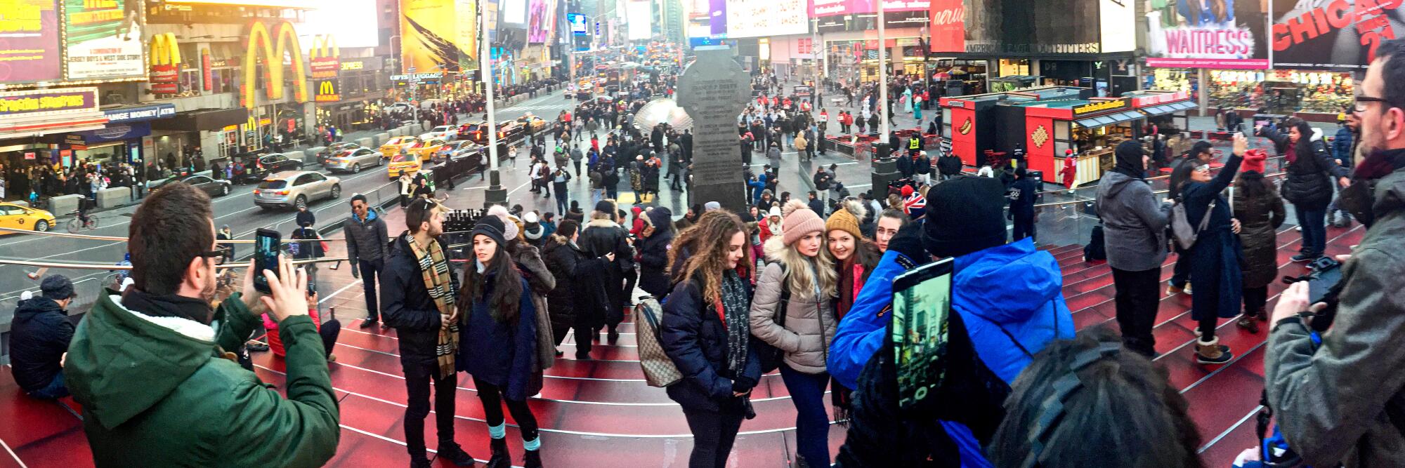 Crowds jostle under bright signs along Broadway. Times Square, New York. 