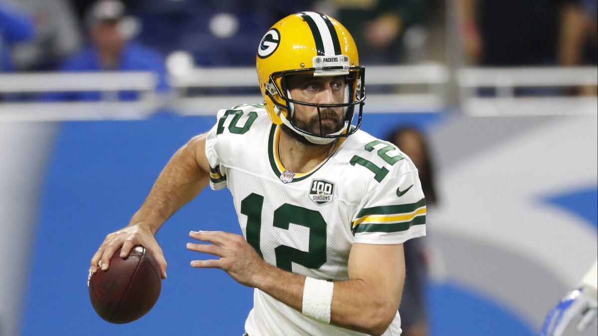 Packers quarterback Aaron Rodgers scrambles against the Lions.