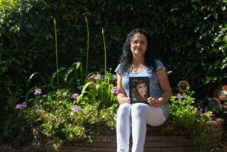 Escondido, California - July 28: Lynn Solorzano sits with a portrait of her daughter in the garden she made in her memory at her home in Escondido, California on Friday, July 28, 2023. (Jessica Parga / The San Diego Union-Tribune)