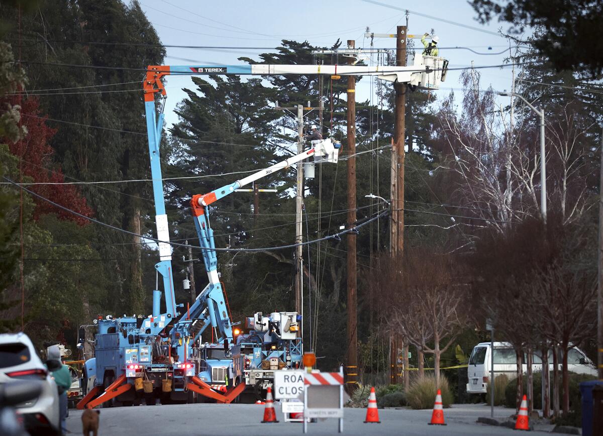 PG&E workers replace equipment damaged by high winds.