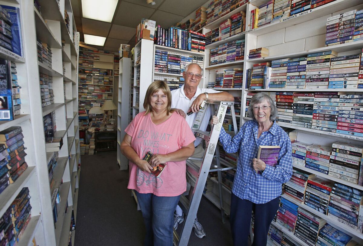 Sharon Patch, Bob Williams and Flora Schoonover, from left, at Books on Broadway, a bookstore owned by Patch. The Costa Mesa store was going to close its doors, but some last-minute aid helped keep it afloat.