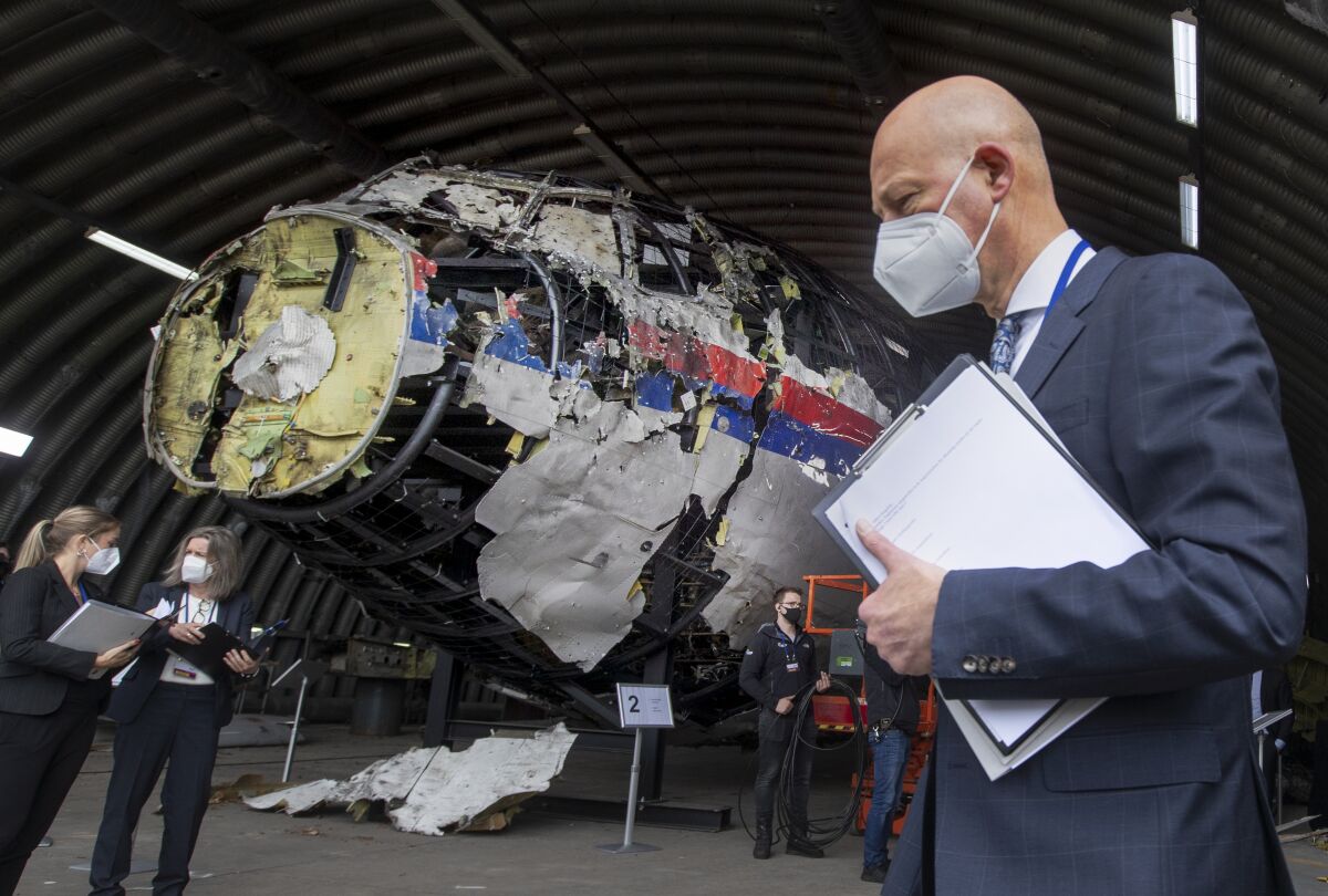 FILE - Presiding judge Hendrik Steenhuis, right, and other trial judges and lawyers view the reconstructed wreckage of Malaysia Airlines Flight MH17, at the Gilze-Rijen military airbase, southern Netherlands, Wednesday, May 26, 2021. A Russian suspect in the 2014 downing of Malaysia Airlines flight MH17 over eastern Ukraine appealed in a video statement to a Dutch court on Friday, June 10, 2022 to be declared innocent, as judges adjourned the long-running trial of three Russians and a Ukrainian separatist rebel and began months of deliberations to reach verdicts. (AP Photo/Peter Dejong, Pool, File)