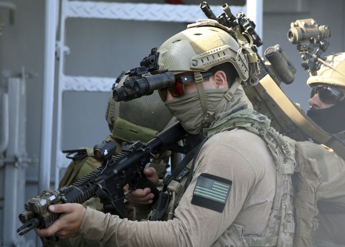 A U.S. Navy SEAL special forces operator, front, and colleagues during a joint U.S.-Cyprus military drill at Limassol port on Friday, Sept. 10, 2021. Cyprus' Defense Minister Charalambos Petrides said the U.S. and Cyprus are on the same strategic path to ensure security and stability in a turbulent region and that continued close cooperation between the special forces of both countries aim to counter threats from potential terrorist acts. (AP Photo/Philippos Christou)