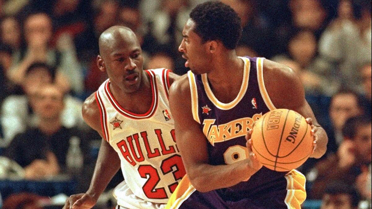 Chicago Bulls great Michael Jordan, left, guards Lakers star Kobe Bryant during the 1998 NBA All-Star game.