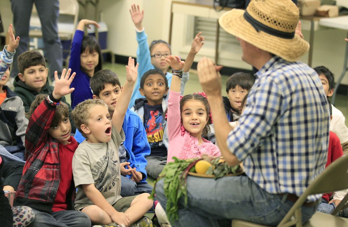 Knight quizzes Castlebay Lane Charter School students on the health benefits of sweet potatoes as he shows off some of the fresh produce he grows on his Redlands farm.