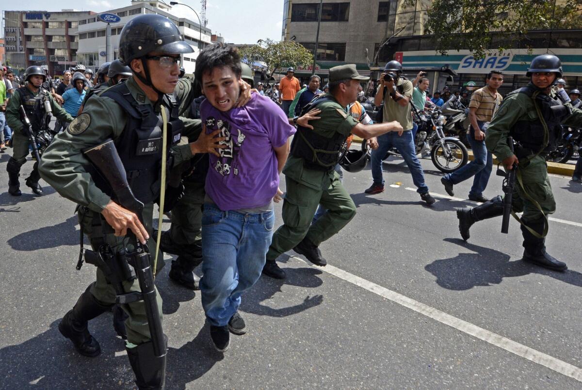 Venezuelan National Guard members in Caracas arrest a demonstrator during a protest against the government of President Nicolas Maduro and to protect him from being attacked by pro-Maduro motorcyclists.