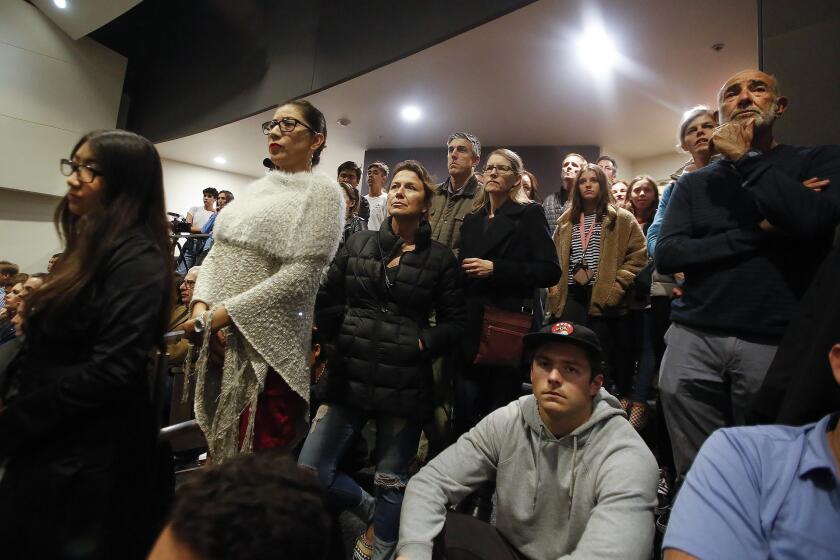 Students, parents and other members of the community listen to a town hall-style discussion Monday night at Newport Harbor High School concerning pictures that emerged from an off-campus party that showed students saluting a swastika made of red cups.