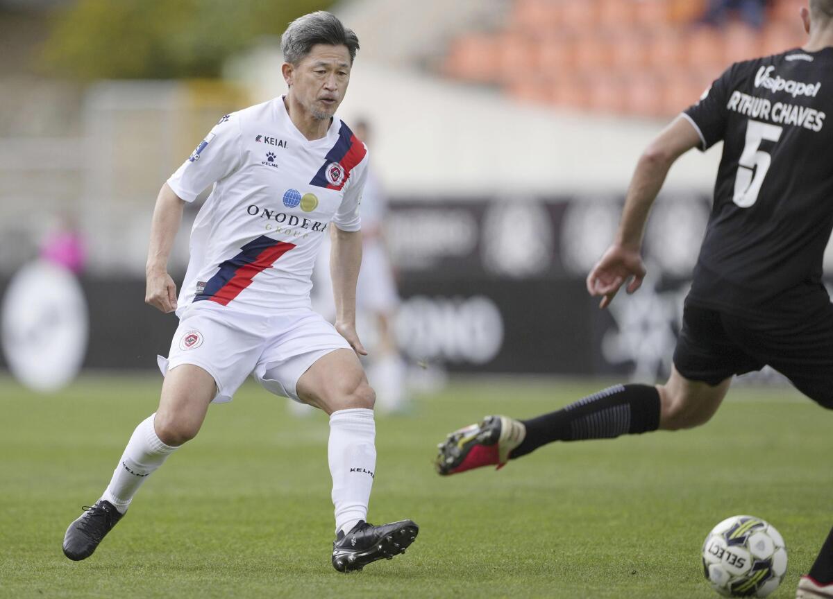 Former Japan forward Kazuyoshi Miura, left, plays for Oliveirense in the second half of a football match against Academico de Viseu in Viseu, Portugal, on April 22, 2023. Miura, who is 56, has signed a new loan deal in Portugal, the second-tier club Oliveirense posted on social media on Tuesday, July 11, 2023. (Kyodo News via AP)