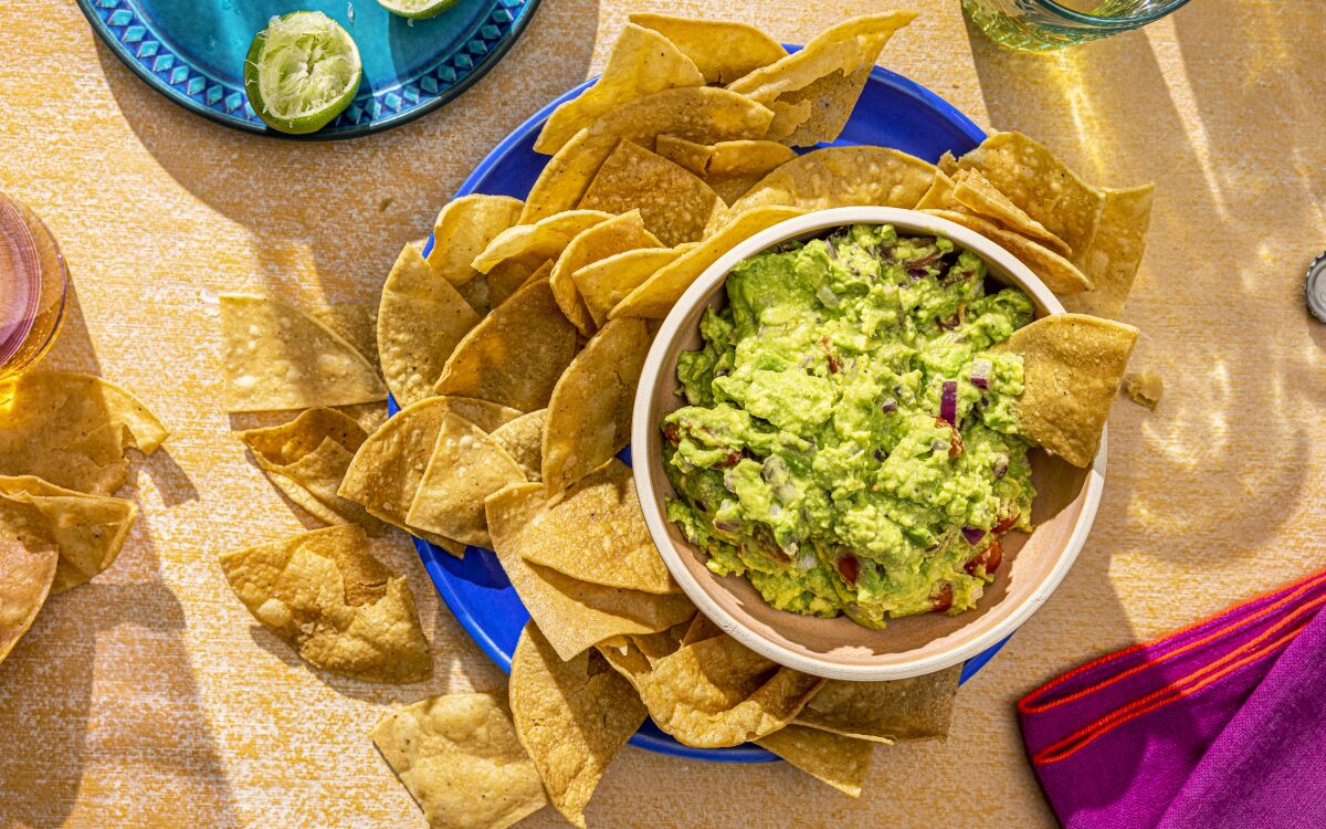 Loads of lime juice perks up this simple guacamole spiked with raw red onions and cherry tomatoes.