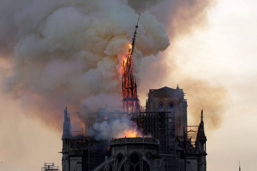 TOPSHOT - The steeple and spire of the landmark Notre-Dame Cathedral collapses as the cathedral is engulfed in flames in central Paris on April 15, 2019. - A huge fire swept through the roof of the famed Notre-Dame Cathedral in central Paris on April 15, 2019, sending flames and huge clouds of grey smoke billowing into the sky. The flames and smoke plumed from the spire and roof of the gothic cathedral, visited by millions of people a year. A spokesman for the cathedral told AFP that the wooden structure supporting the roof was being gutted by the blaze. (Photo by Geoffroy VAN DER HASSELT / AFP) (Photo by GEOFFROY VAN DER HASSELT/AFP via Getty Images)