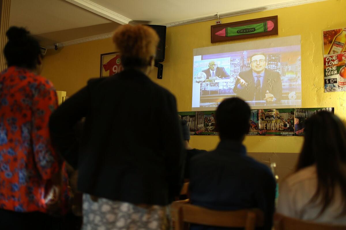People gather to watch John Oliver's television broadcast at How'Zat sports bar in Port of Spain, Trinidad And Tobago.